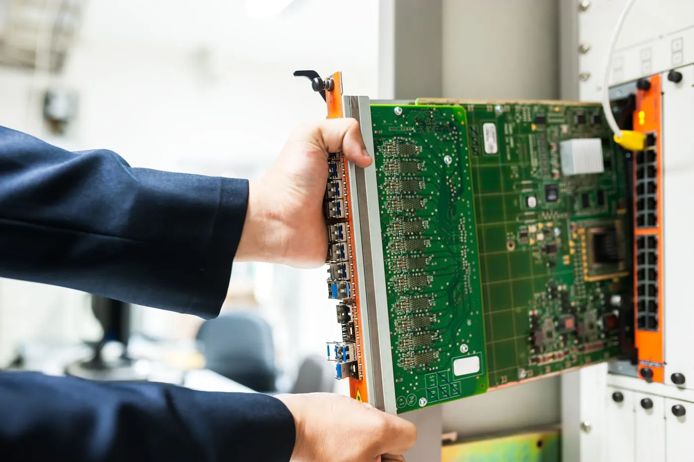 Engineer installing a network card in a server rack